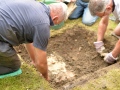 Carefully removing soil from archaeological feature in Test Pit 2.