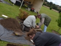 Removing and sifting soil from Test Pit 2.