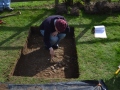 Use of an archaeological trowel to expose the archaeological feature.