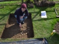 Happy little worker exposing archaeological feature with trowel.
